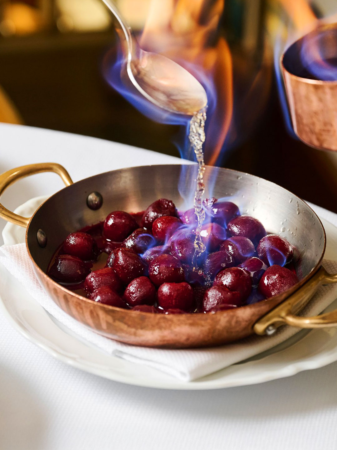 Cherries jubilee for two, prepared tableside at Café Carmellini. © Café Carmellini 