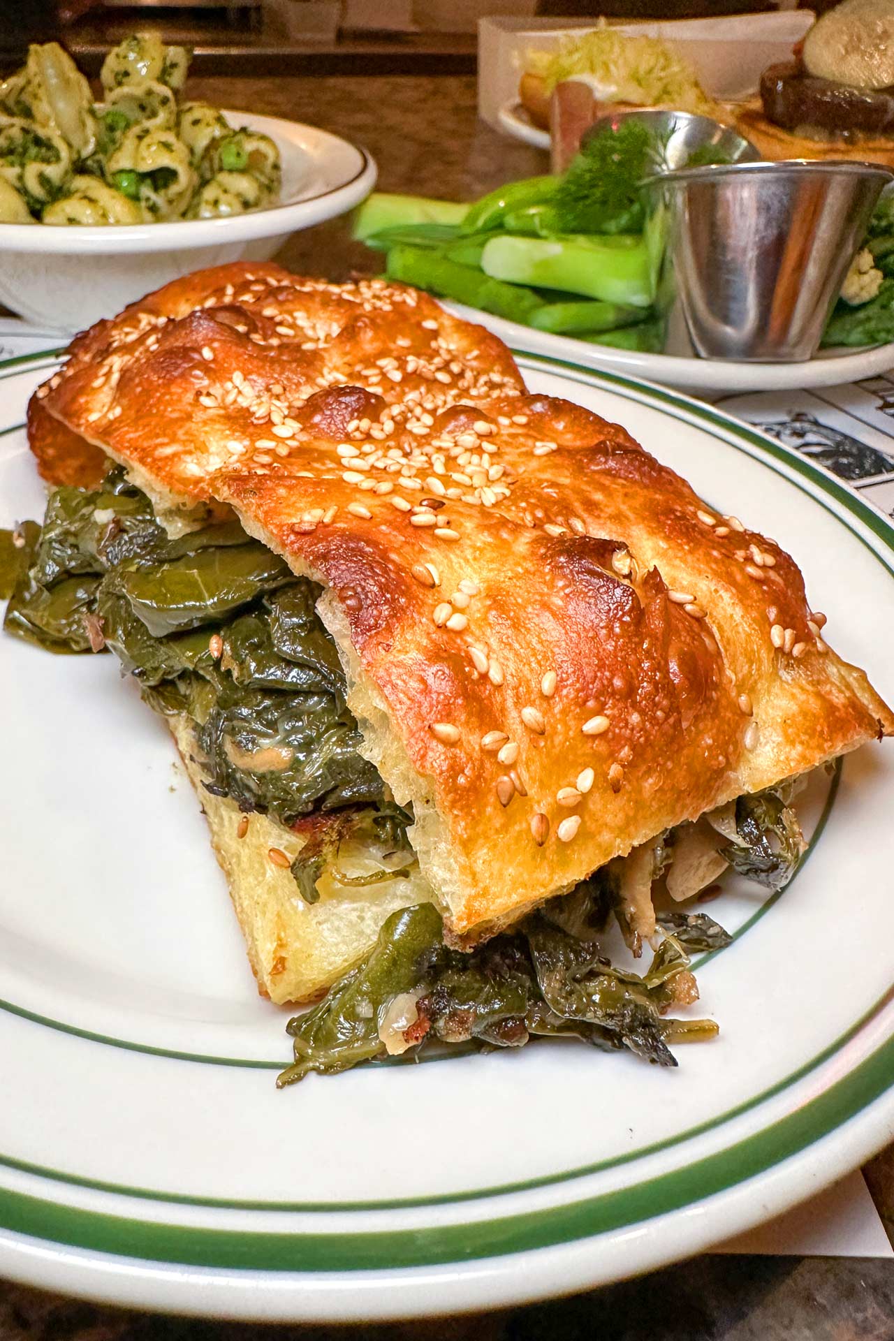 The collard greens sandwich is layered with braised collards and melty cheddar cheese on irresistible sesame seed focaccia. © Mike J Chau/Superiority Burger