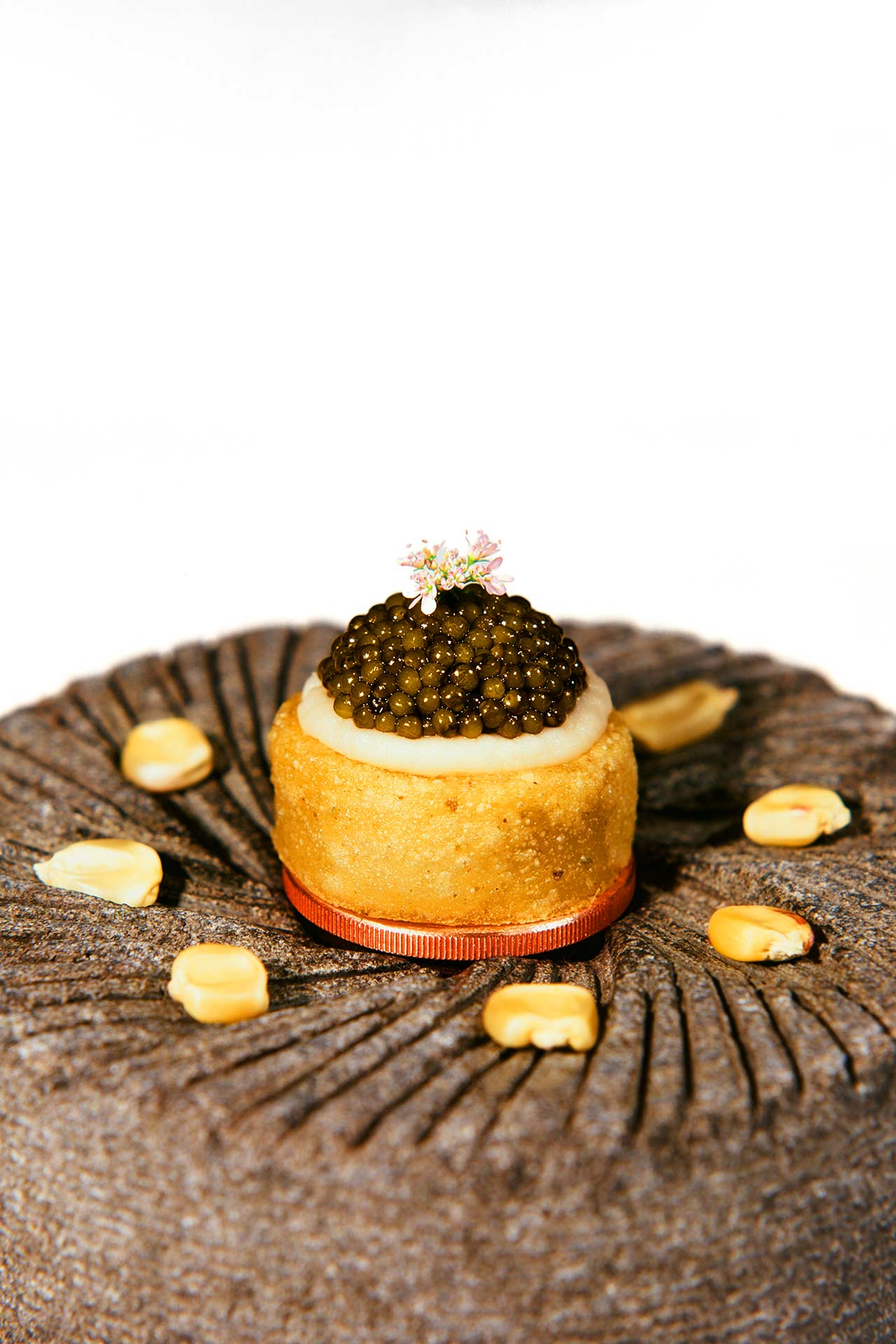 Sope with caviar served on a masa grinder. © Val Cantú/Californios