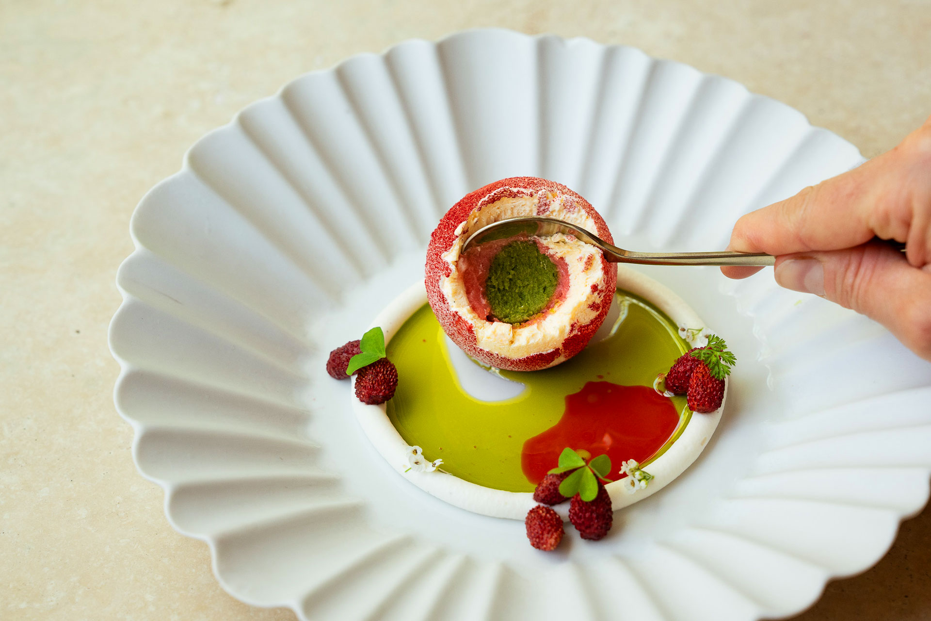 The alpine strawberry sphere at Quince features multiple flavors of gelato, is served with lemon verbena cream and is finished tableside with strawberry consommé and lemon verbena oil.  © Camille Vance