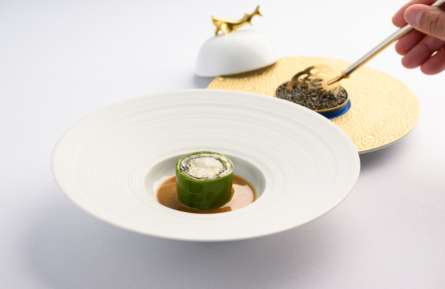 Caviar being added to a fish dish from MICHELIN-Starred The Samling. © R Zahler/The Samling
