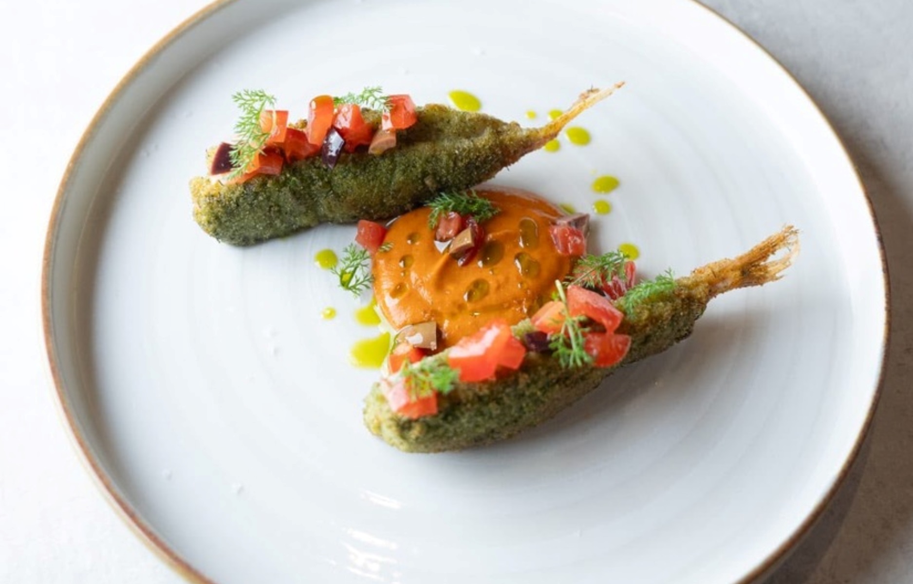 Alici fritte e croccanti, arricchite da note vegetali e mediterranee, in un piatto che unisce tradizione e leggerezza contemporanea. © Osteria Stella
